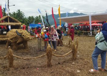 Pengunjung Manfaatkan Hiasan Jerami Berbentuk Kerbau untuk Abadikan Momen Bersama Keluarga